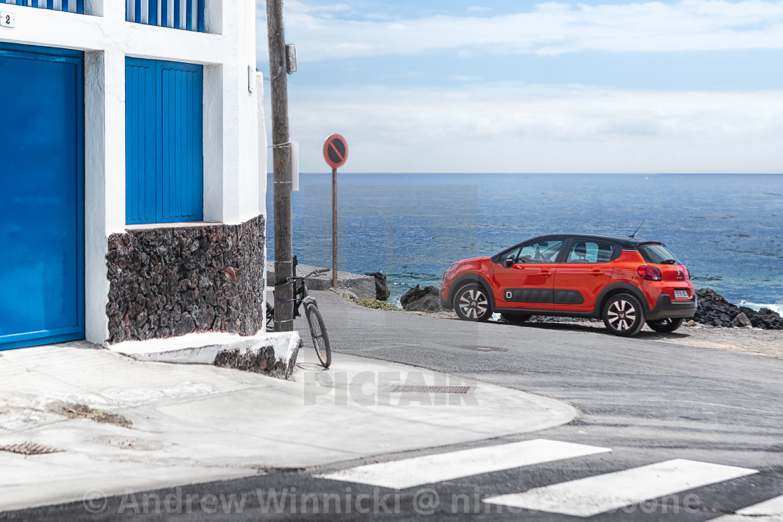 "An orange small car on holiday island, town" stock image