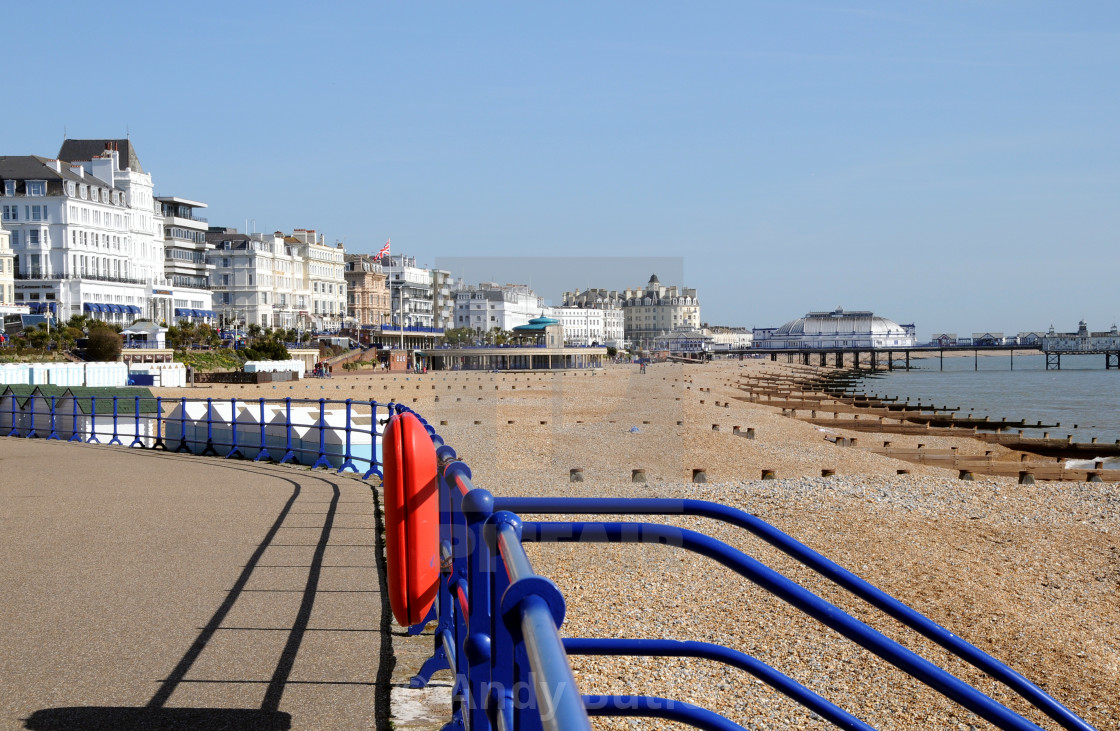 "Beach with railings in foreground looking towards pier. ERastbourne, East Sussex, England." stock image