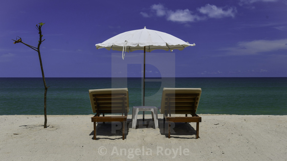 "Tropical beach, sunloungers and white parasol" stock image