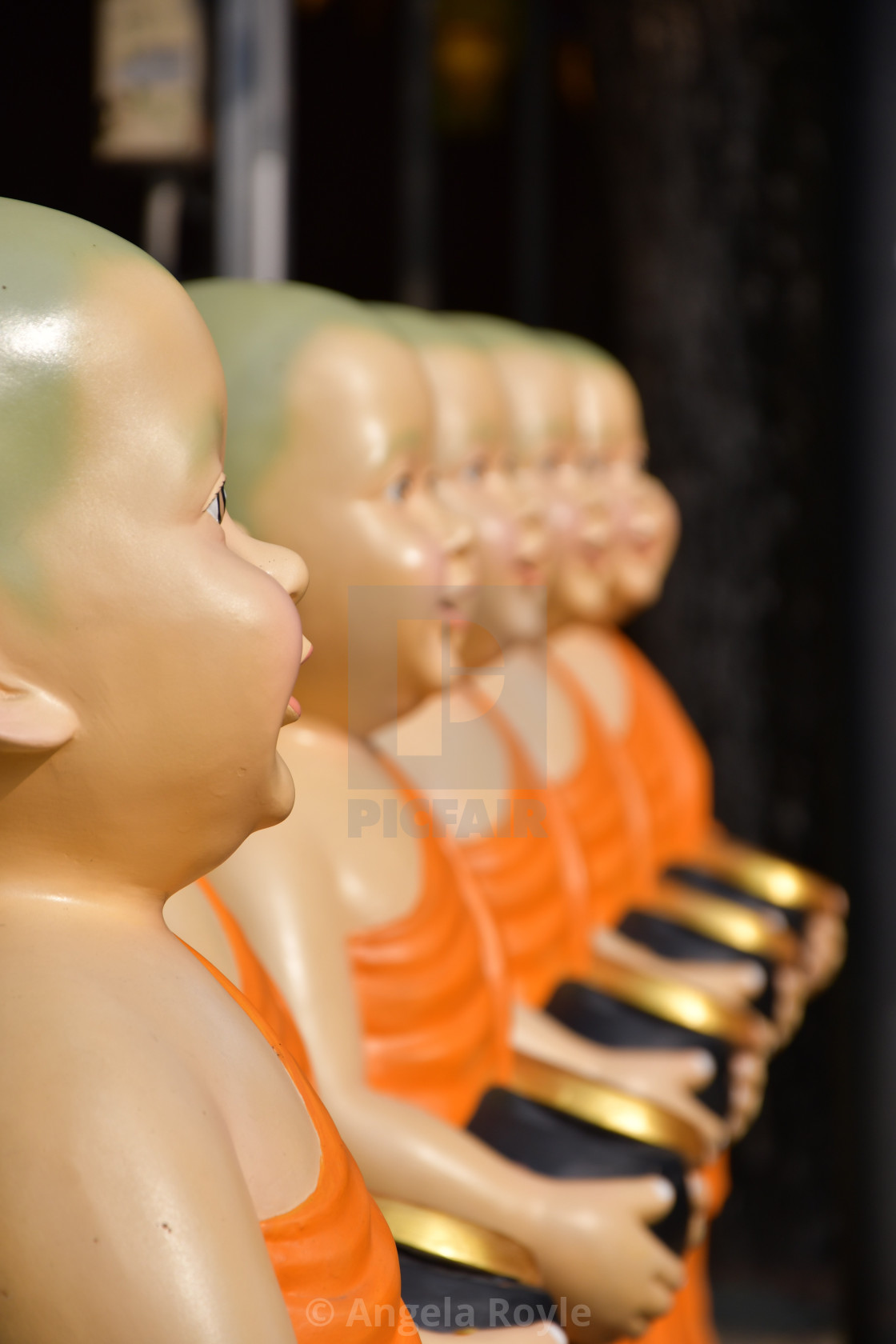 "Monk statues holding alms bowls" stock image