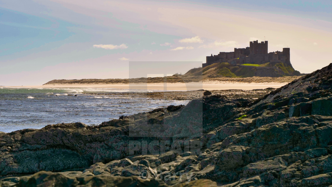 "Bamburgh Castle & Beach on a blustery day in March 2021" by Barry - £12.40 "Bamburgh Castle & Beach on a blustery day in March 2021" stock image
