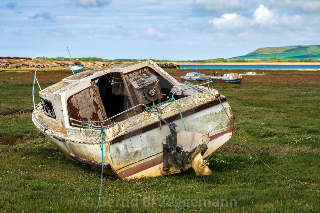 "A damaged Boat in the grass, seen in Askam-in-Furness, Cumbria, England" stock image