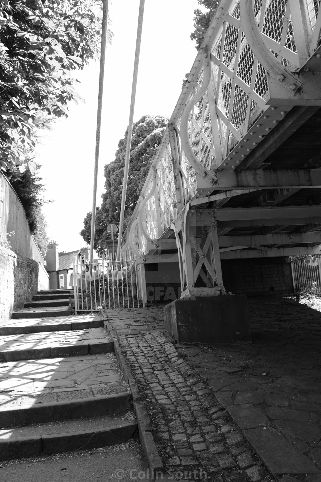 "Steps from the river bank to the suspension bridge." stock image