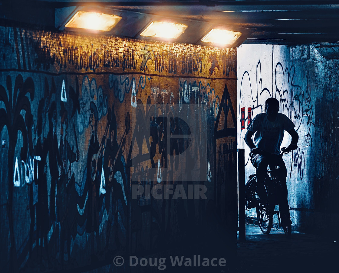 "Cyclist cycling through Subway from East Road, Cambridge UK." stock image