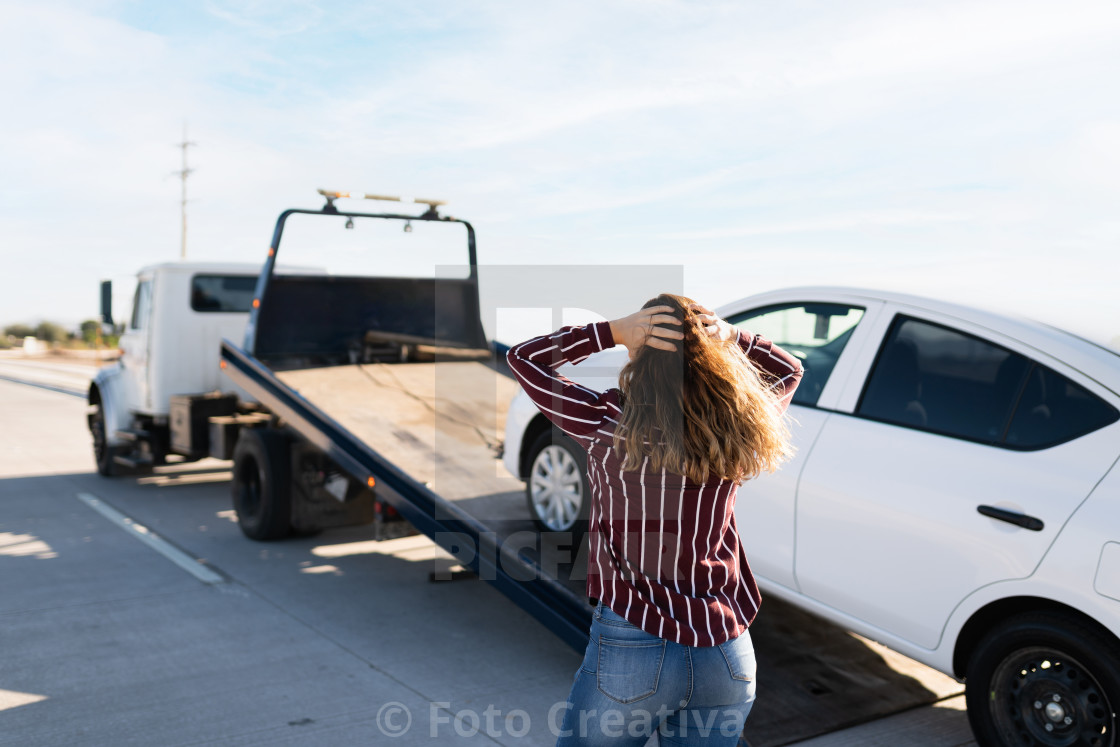 "Angry woman seen from behind and watching her car on a tow truck" by Foto Creativa - £3.80 "Angry woman seen from behind and watching her car on a tow truck" stock image