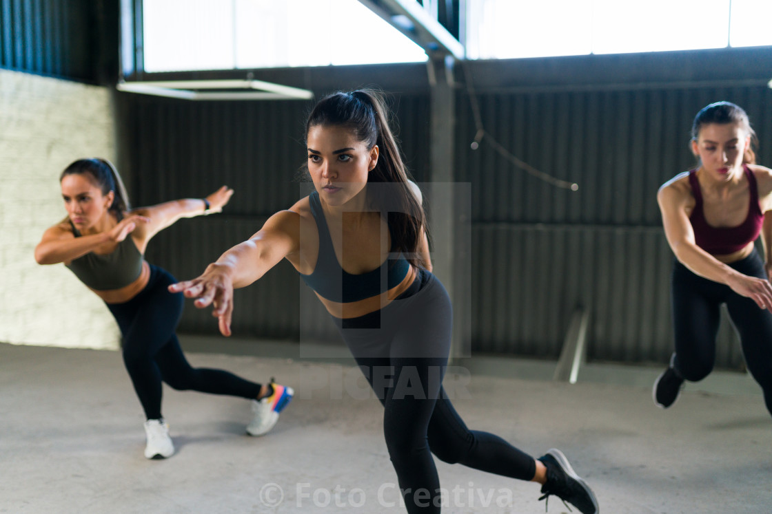 "Three women doing a workout exercises indoors" by Foto Creativa - £3.80 "Three women doing a workout exercises indoors" stock image