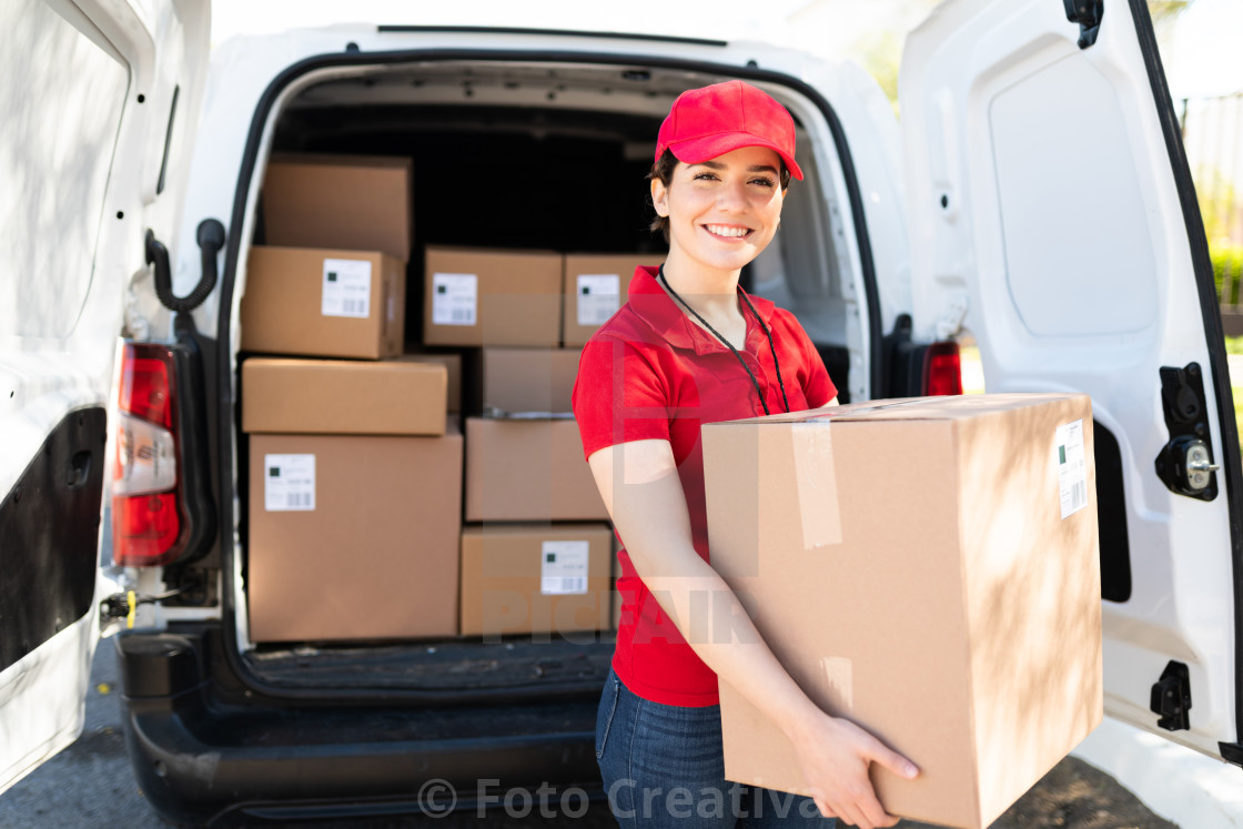 "Female courier and driver carrying a bunch of packages" by Foto Creativa - £3.80 "Female courier and driver carrying a bunch of packages" stock image
