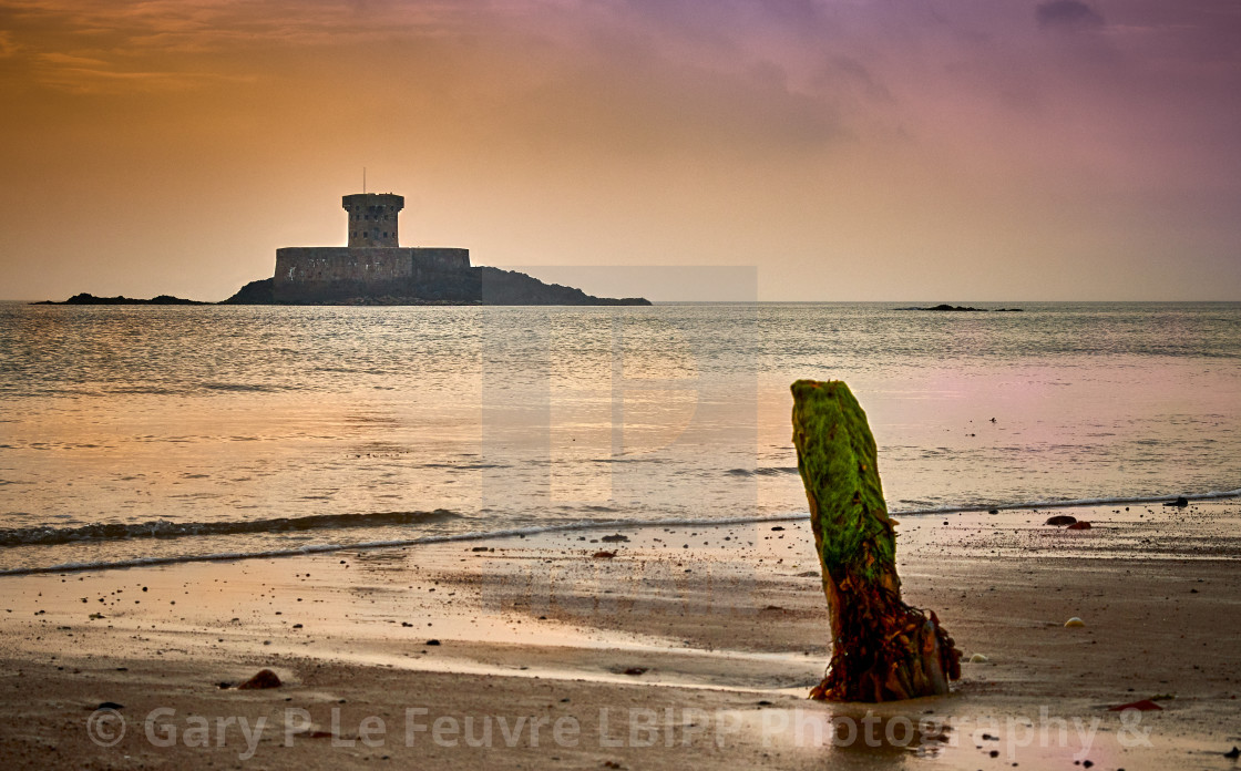 "St Ouens Bay at sunset with Rocco Tower" stock image