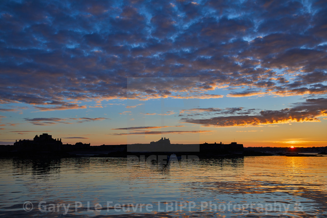 "Elizabeth Castle in silhouette at sunset" stock image