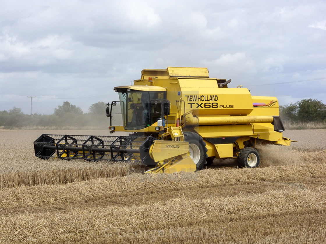 "Combine Harvester working in field in Wicken, Cambridgeshire, UK" stock image