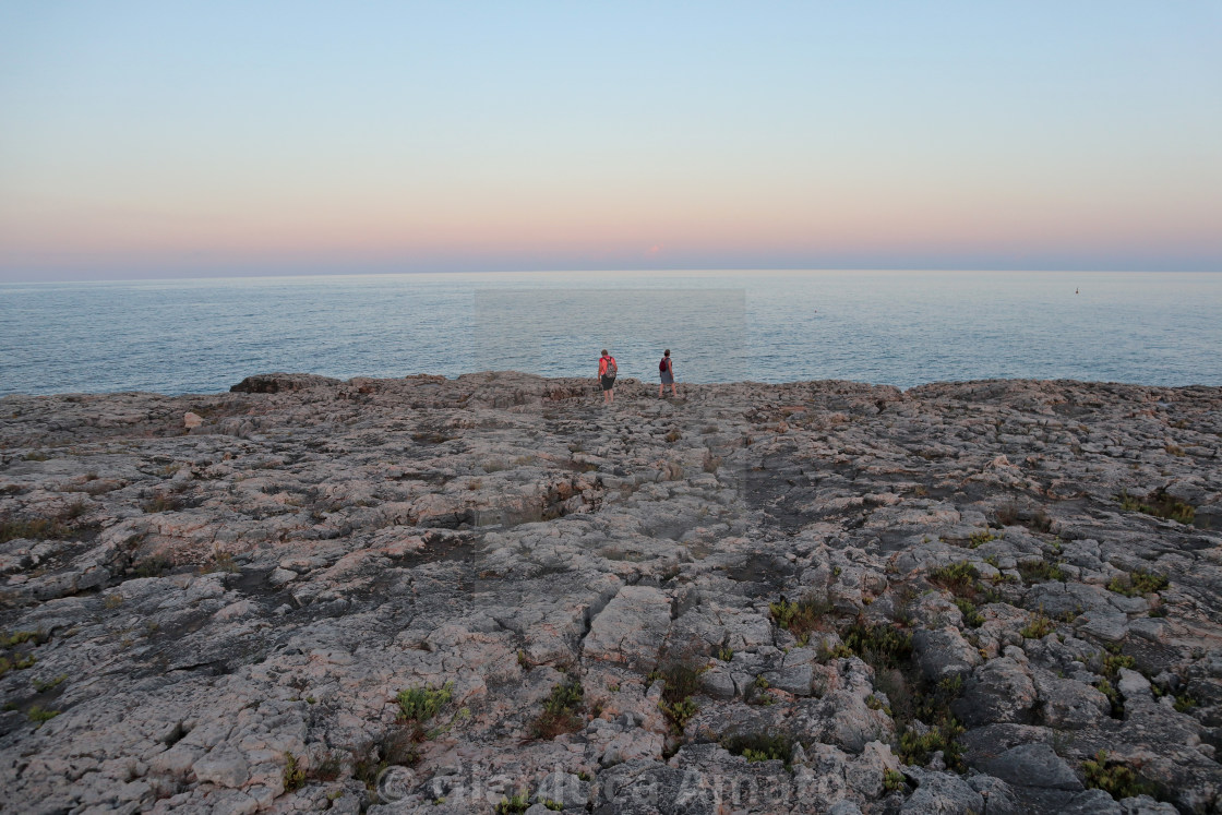 "Siracusa - Turiste sulla scogliera del Plemmirio al tramonto" stock image