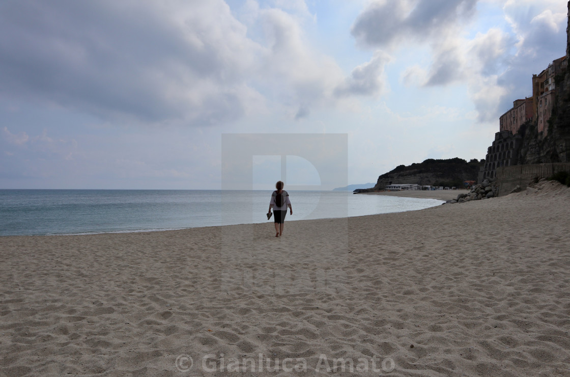 "Tropea - Turista sulla spiaggia dell'Isola Bella al mattino presto" stock image