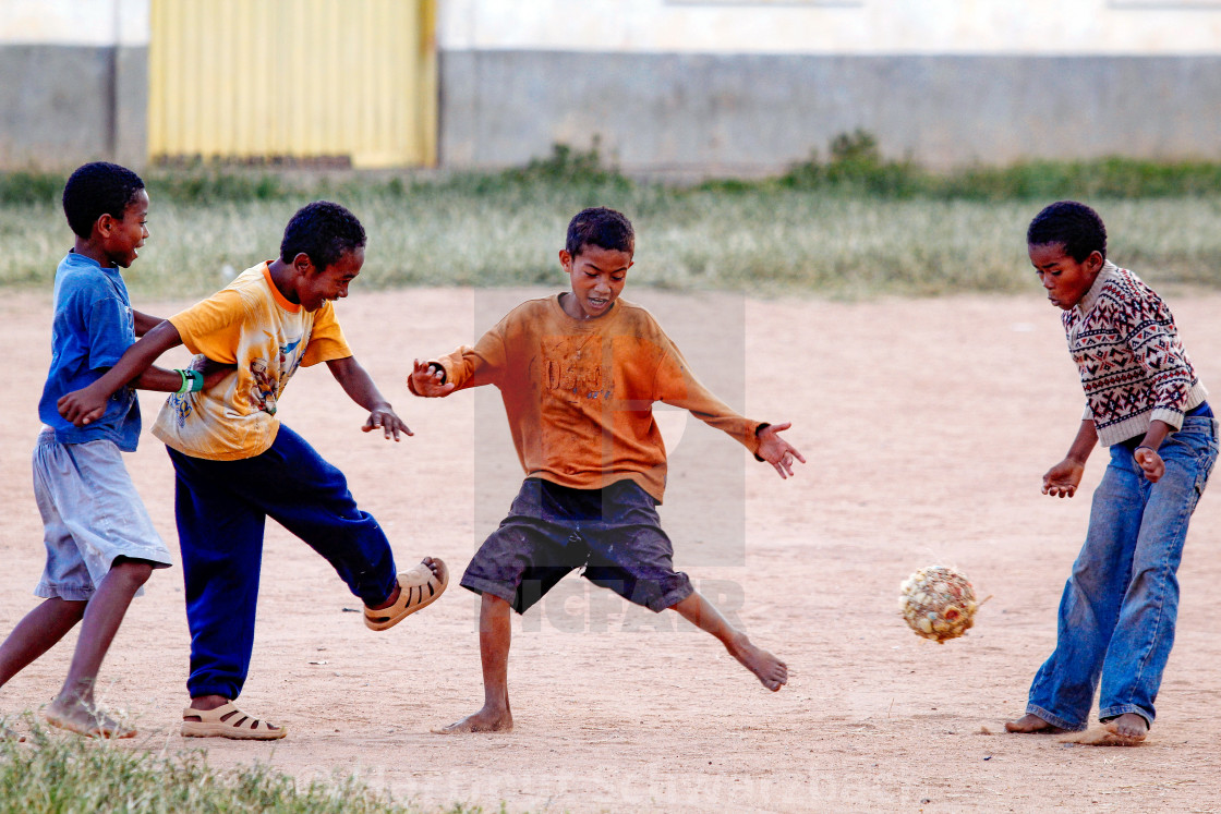 "boys playing football without shoes and self made ball" stock image