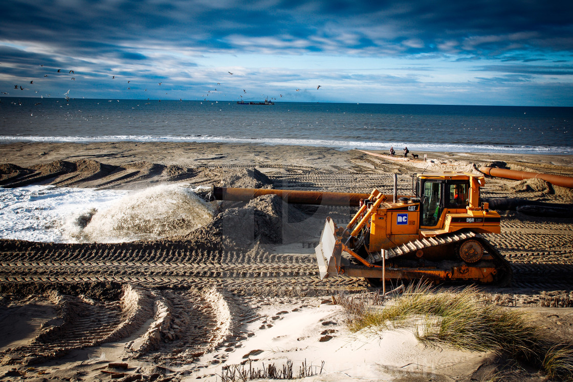 "Sand flushing with heavy equipment to secure the coast and the s" stock image