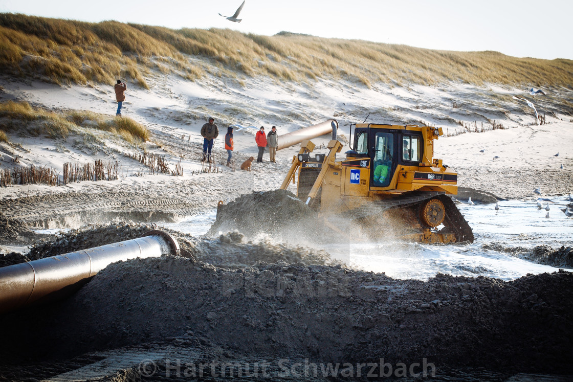 "Sand flushing with heavy equipment to secure the coast and the s" stock image