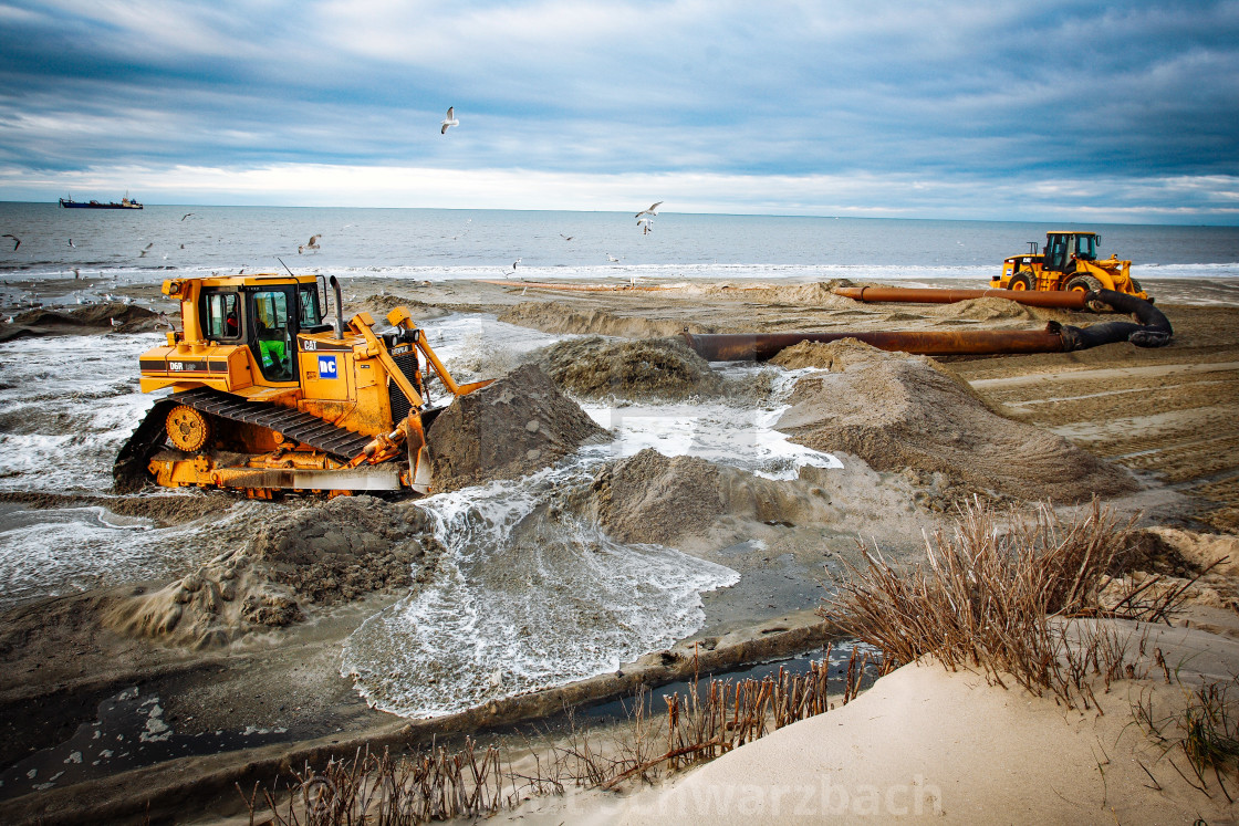 "Sand flushing with heavy equipment to secure the coast and the s" stock image