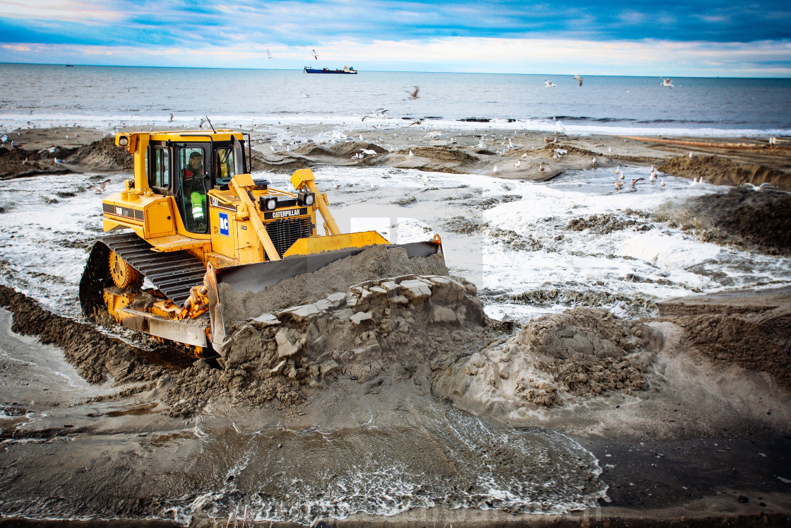 "Sand flushing with heavy equipment to secure the coast and the s" stock image