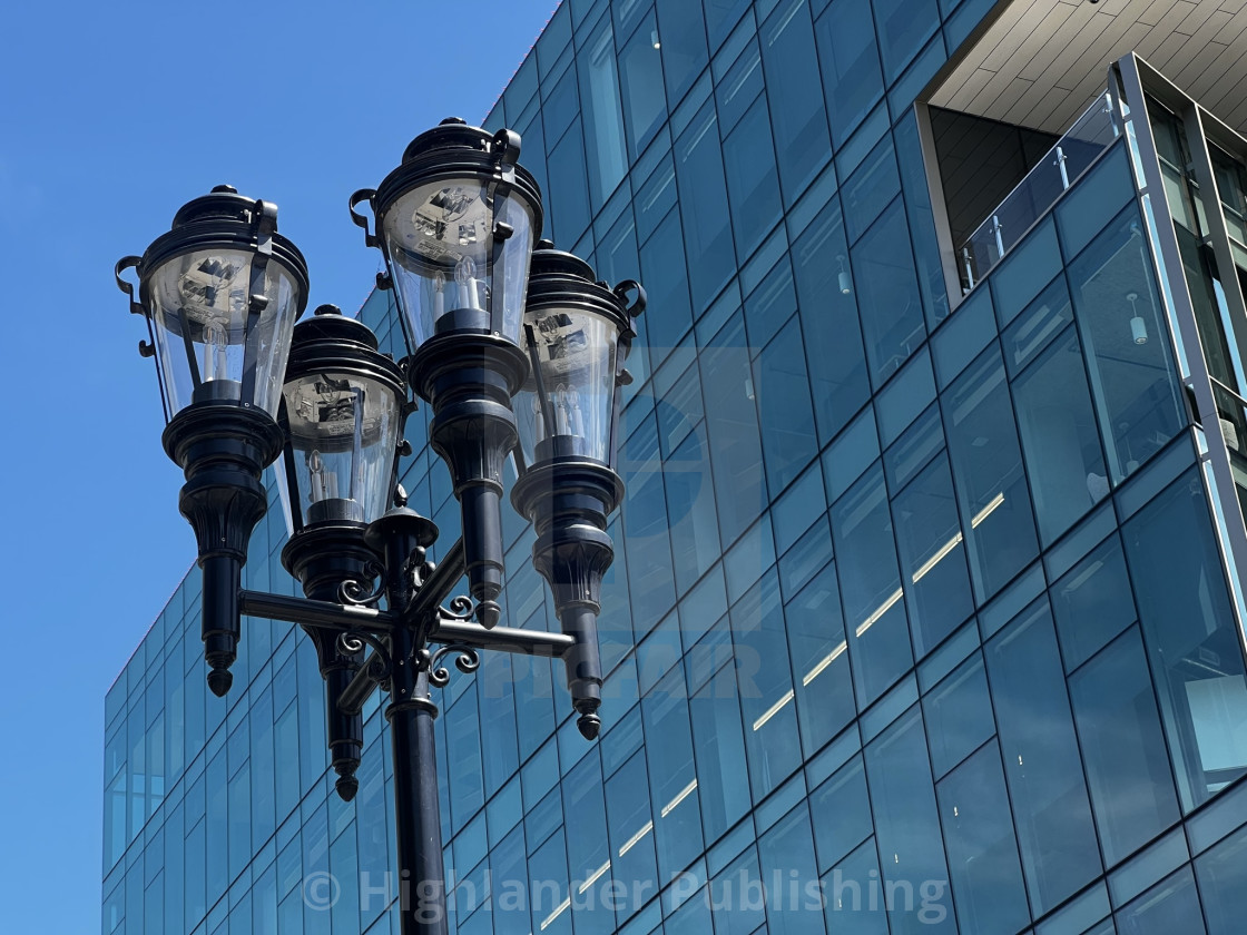 "Antique lamp post against modern building" stock image