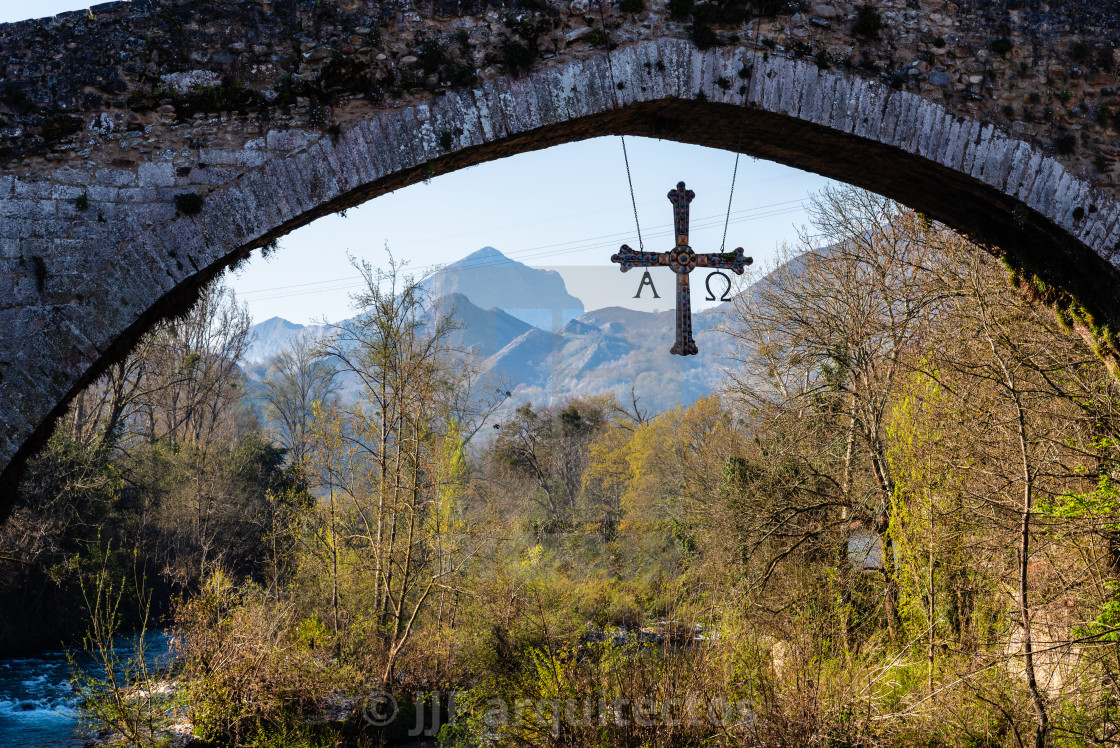 "Cross hanging from old Roman stone bridge with mountains on background" stock image