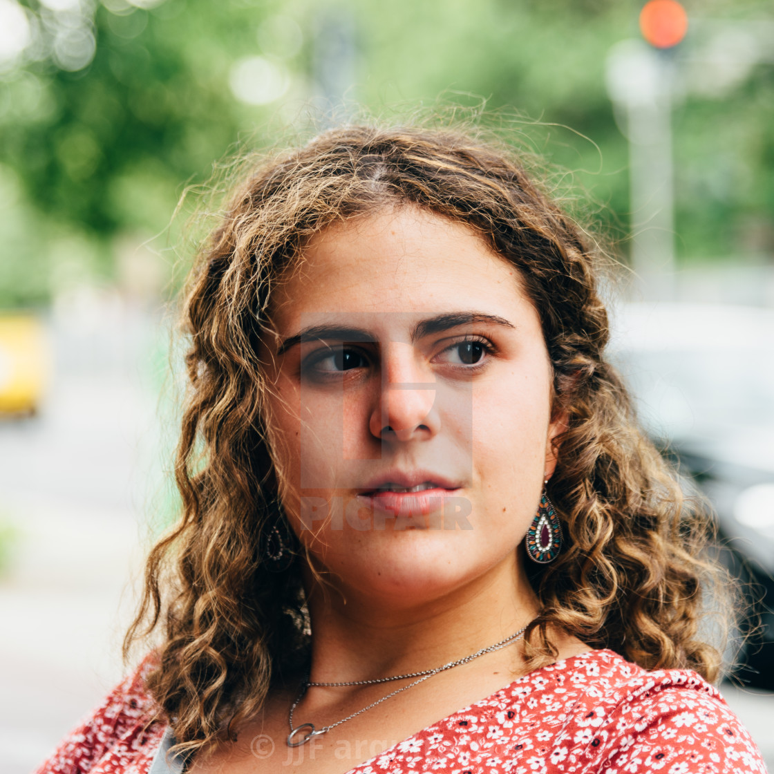 "Headshot portrait of confident beautiful young woman with curly hair" stock image