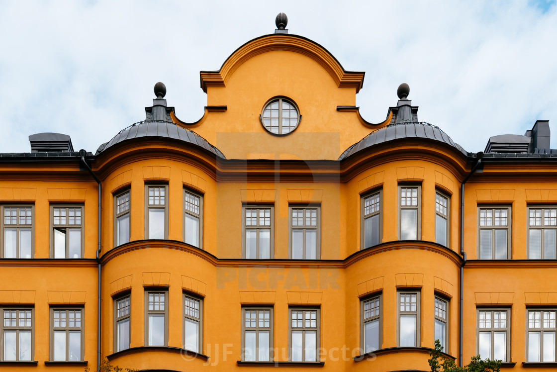 "Traditional residential house in Stockholm. Yellow painted facade against sky" stock image