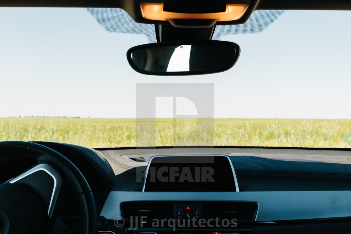 "View of farm fields through the windshield of a car" stock image