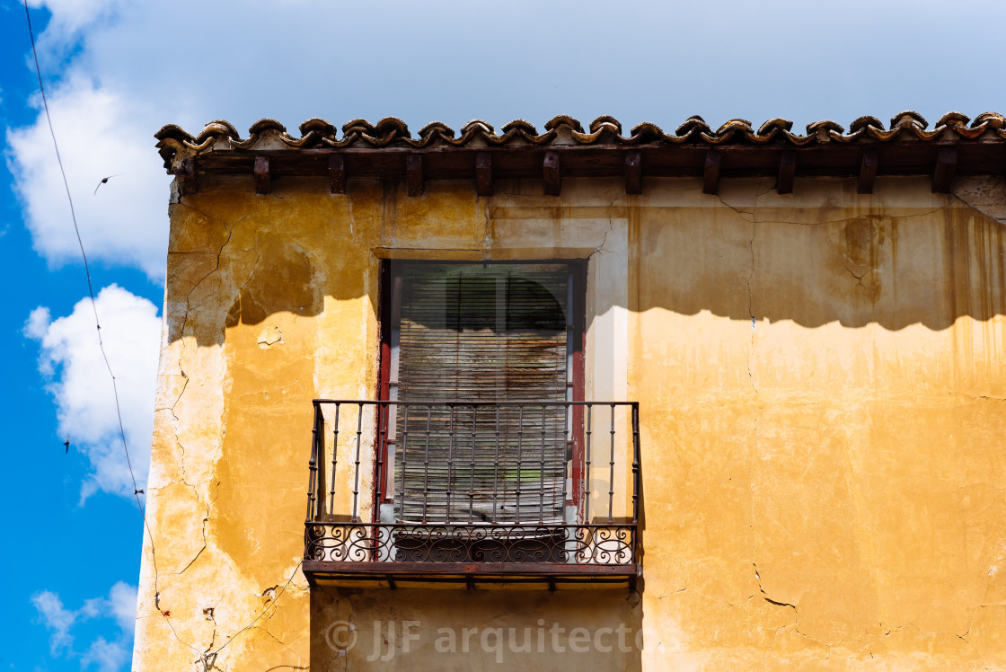 "Old Iron Balcony in Aged Yellow Plaster Facade" stock image