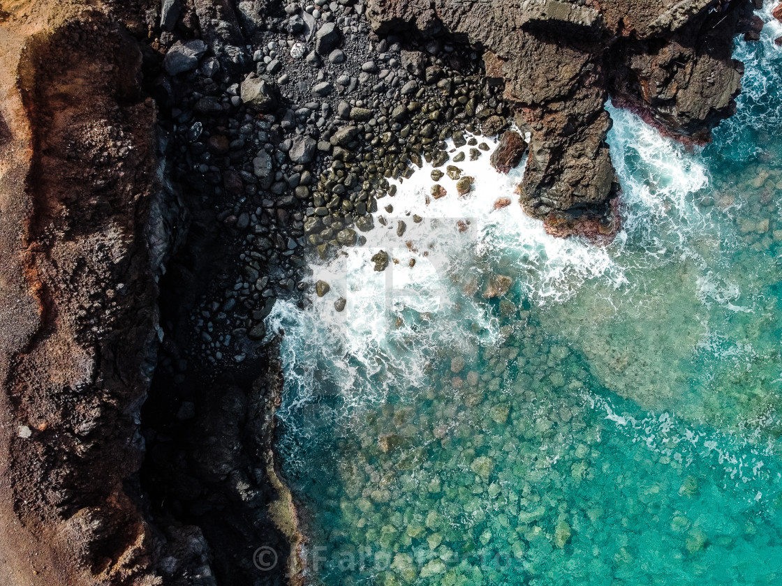 "Aerial view of rocks and sea waves in a volcanic landscape with lava" stock image