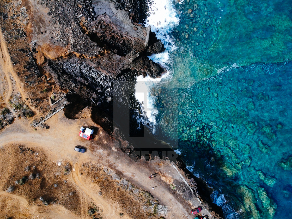 "Aerial view of rocks and sea waves in a volcanic landscape with lava" stock image