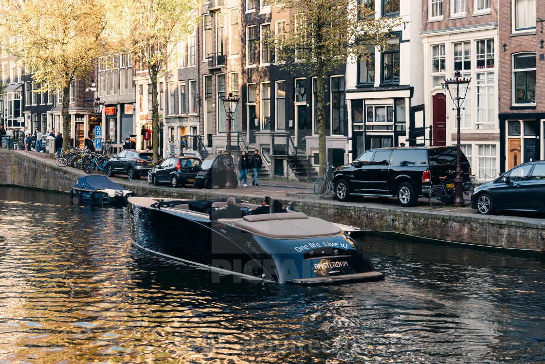 "Boat navigating by canal in Red Light District in Amsterdam" stock image