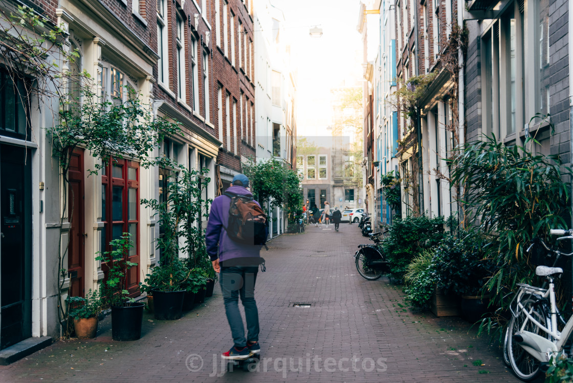 "Young man skating in a picturesque alley in Red Light District" stock image