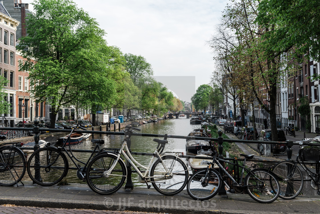 "Bicycles over bridge in canal in the historic centre of MAsterdam" stock image