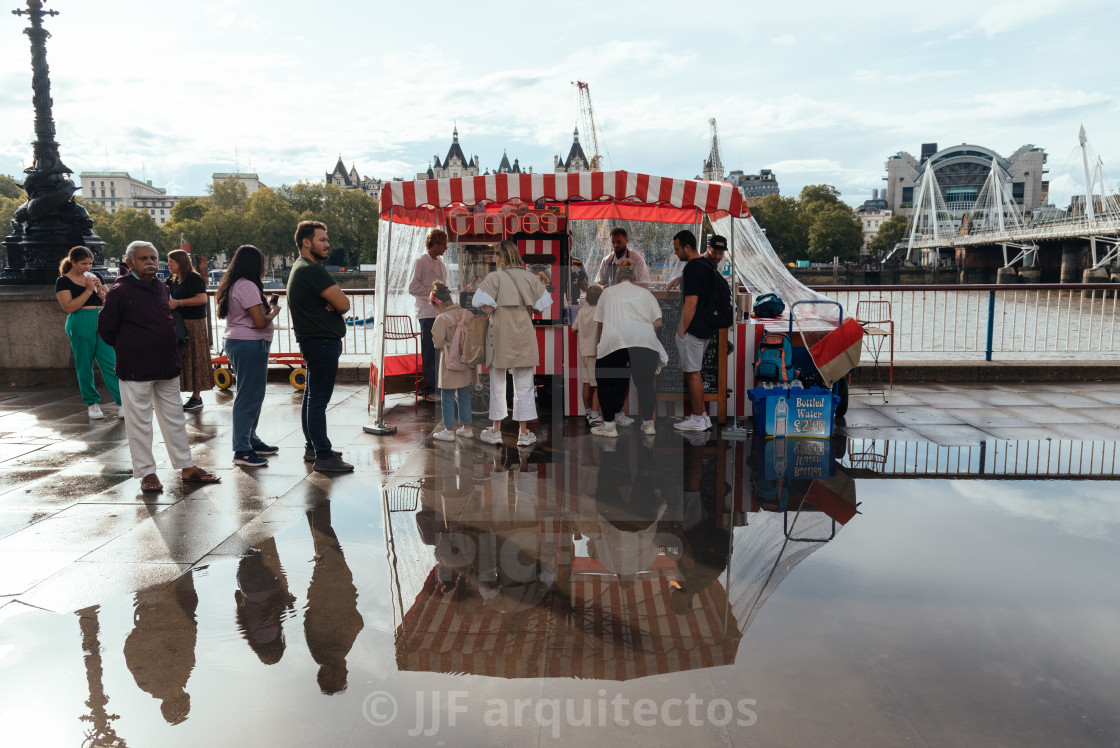 "People enjoying food from crepes food trucks on Thames riverside by London Eye" stock image