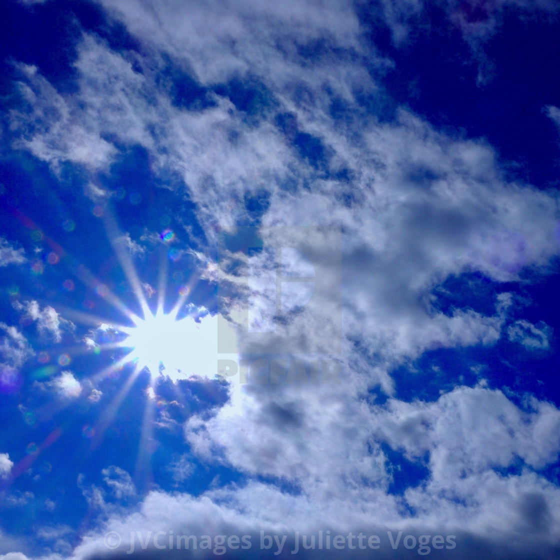 "Cloudy Blue Sky & Sunburst" stock image