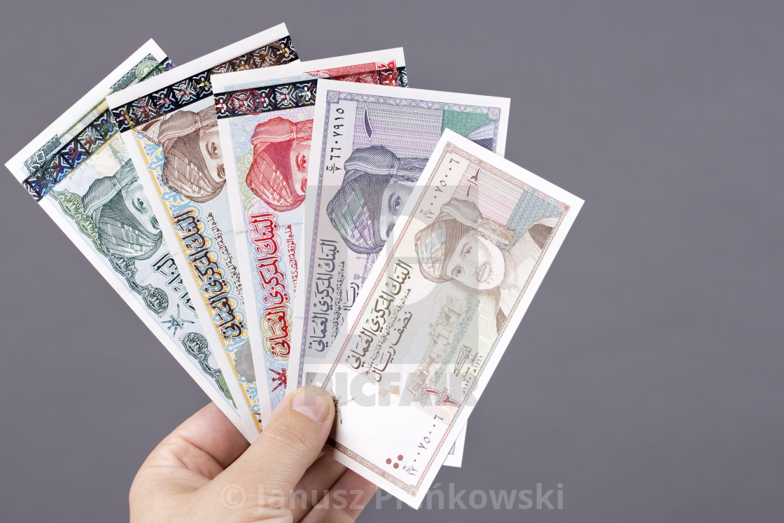 "Old Omani money in the hand on a gray background" stock image