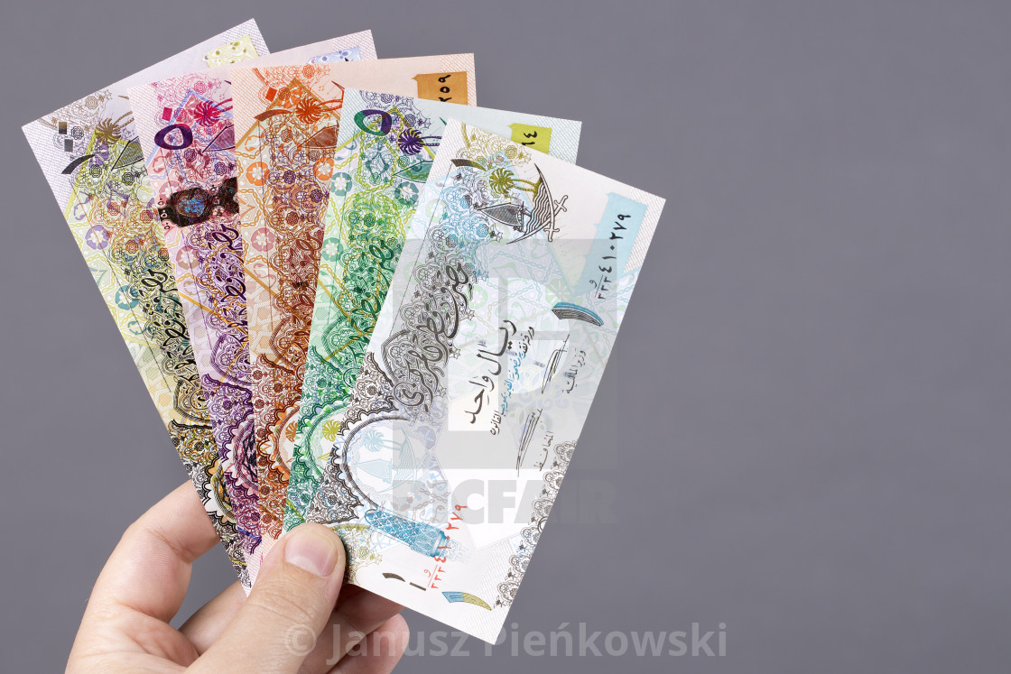 "Qatari money in the hand on a gray background" stock image