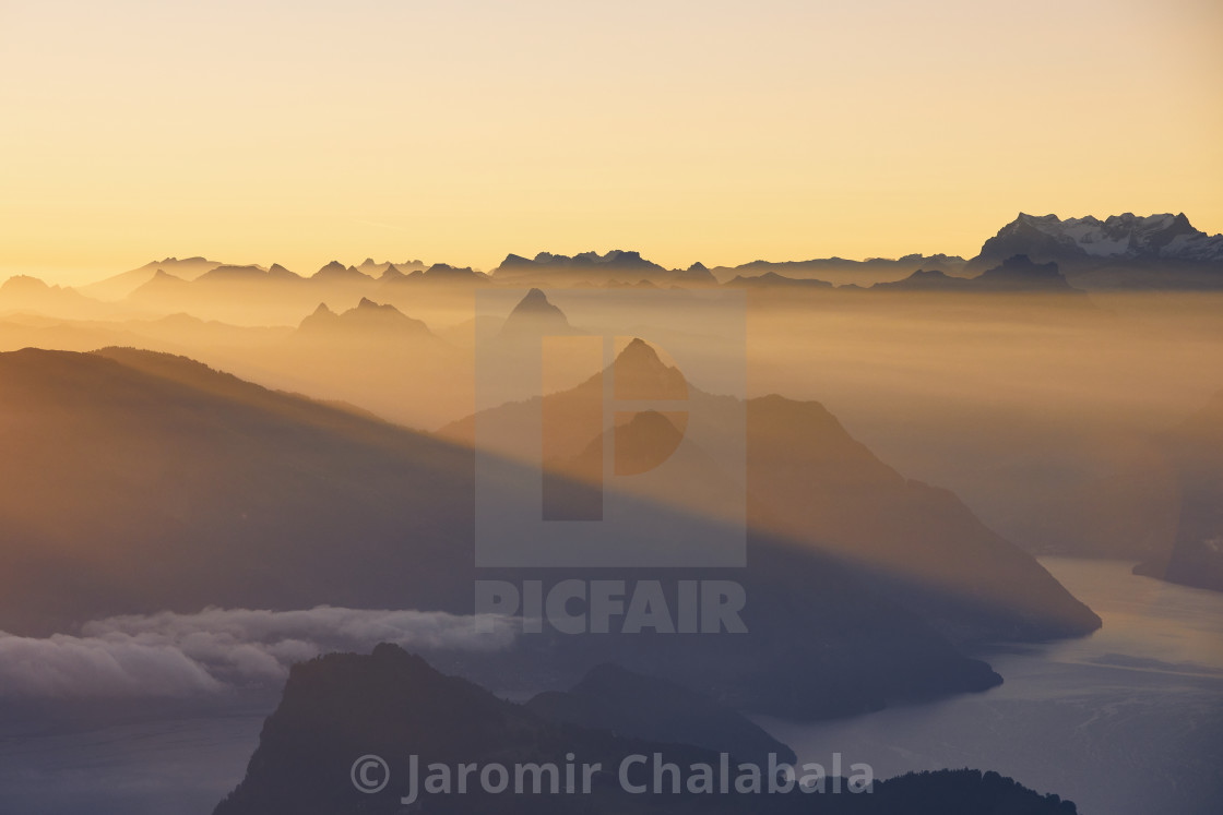 "Scenic view of lake and mountains at sunrise" stock image