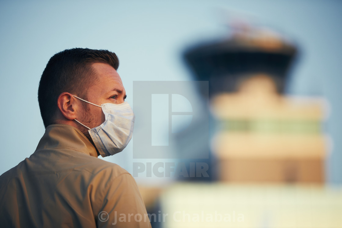 "Man wearing face mask at airport" stock image