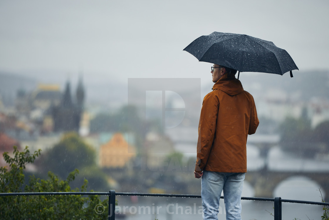 "Man with umbrella during rain in city" stock image