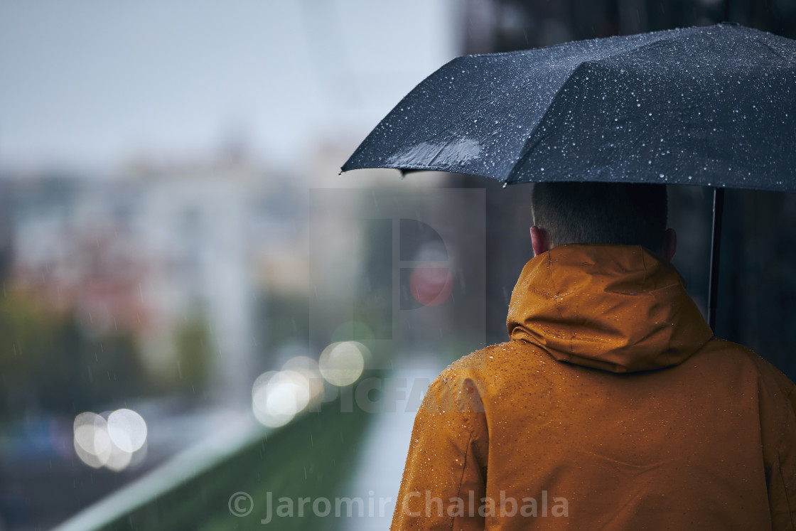 "Man with umbrella during rain in city" stock image