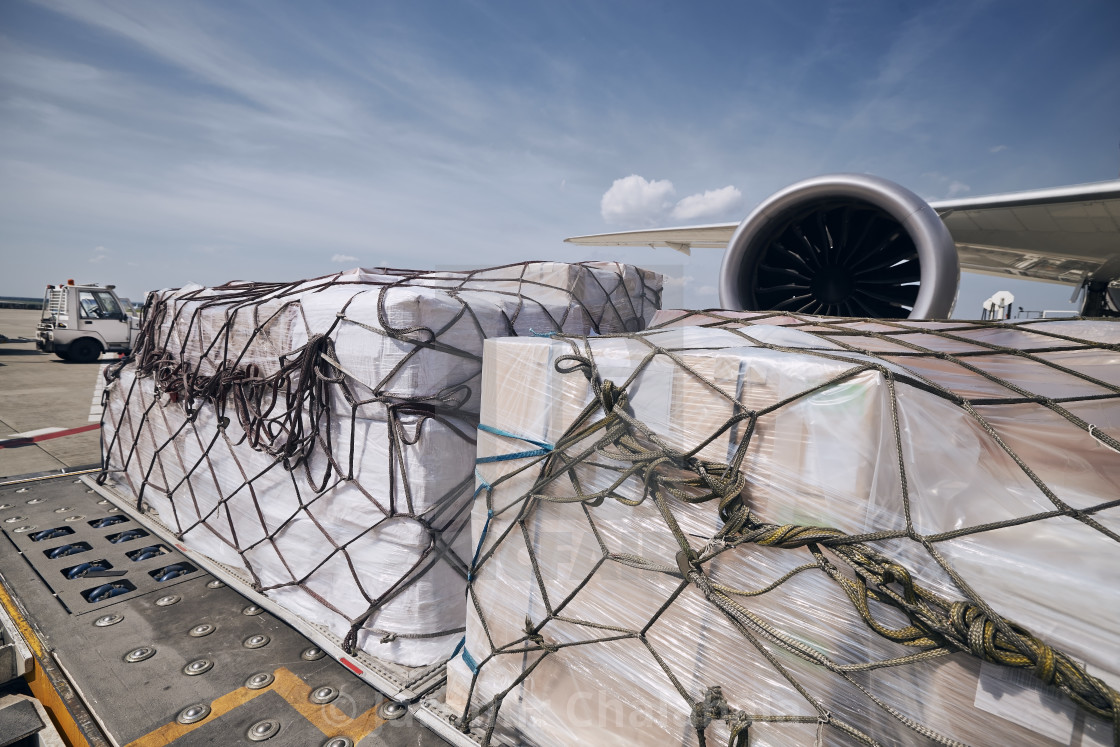 "Cargo containers against jet engine of freight airplane" stock image