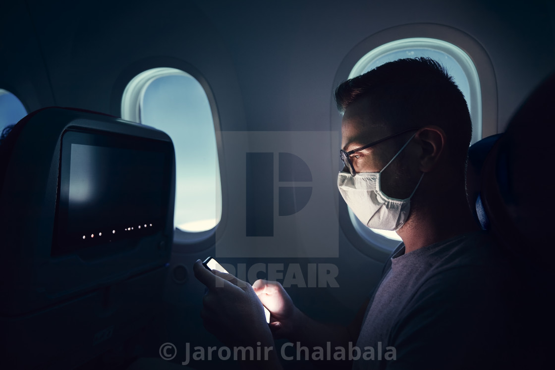 "Man with face mask traveling by airplane" stock image