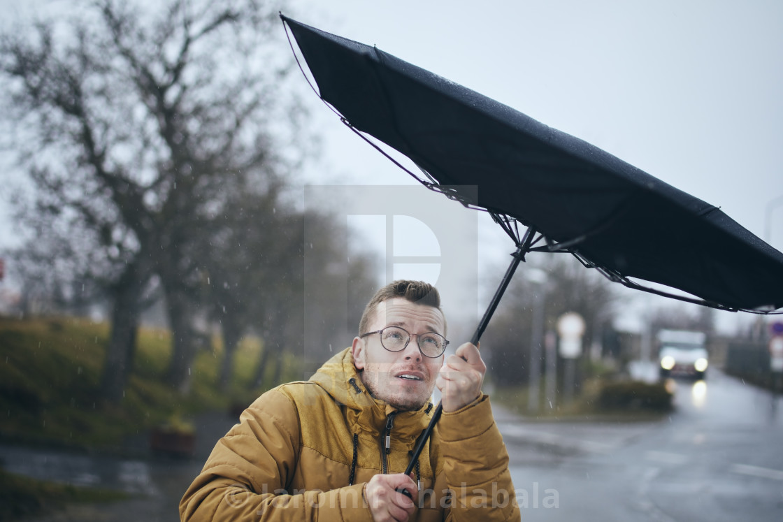 "Man with umbrella in wind and rain" stock image