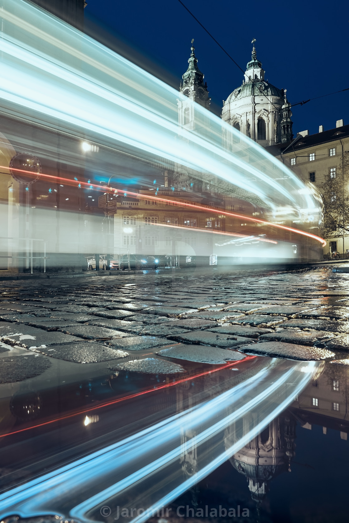 "Light trail of tram passing between historical buildings" stock image