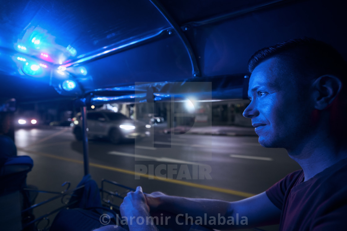 "Man enjoying night tuk tuk ride in Bangkok" stock image