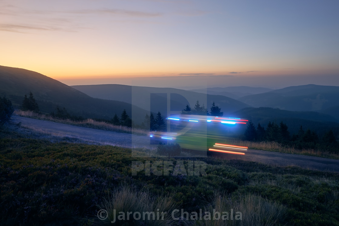 "Light trails of ambulance of emergency medical service on mountain road" stock image