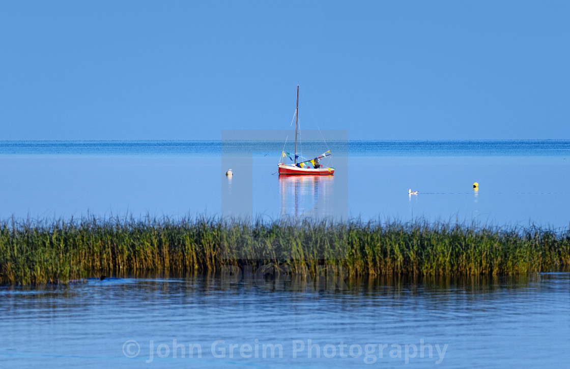 "Red sailboat at Robbins Hill Beach" stock image