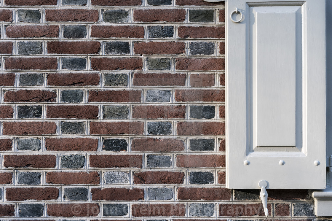 "Colonial house detail with Flemish bond masonry and shutter," stock image