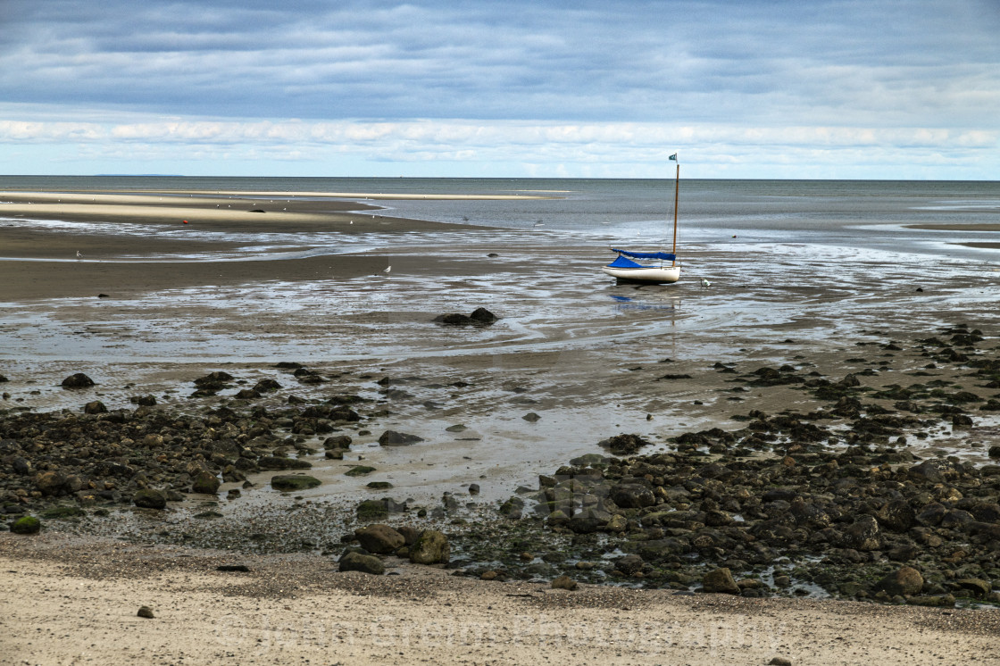 "Sailboat anchored in tidal flats" stock image