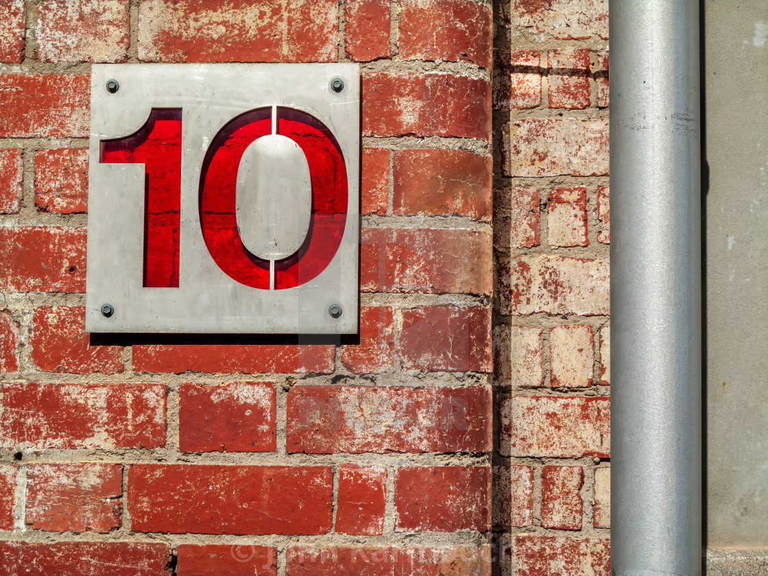 "House Number Ten on Red Brick Wall" stock image